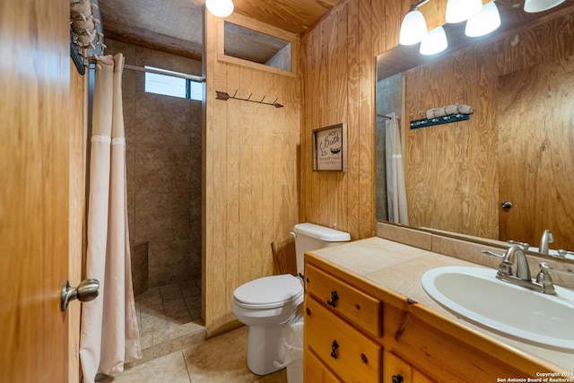 bathroom with a shower with curtain, vanity, wooden walls, tile patterned flooring, and toilet