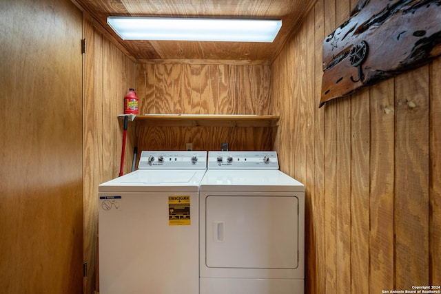 washroom featuring wood walls and washer and dryer