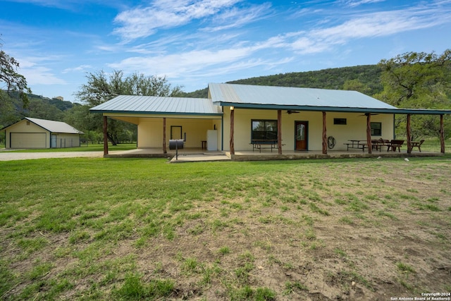 201 N Tomahawk Way, Concan, TX 78801 - view of front of home with a ceiling fan, a front lawn, driveway, metal roof, and a patio area