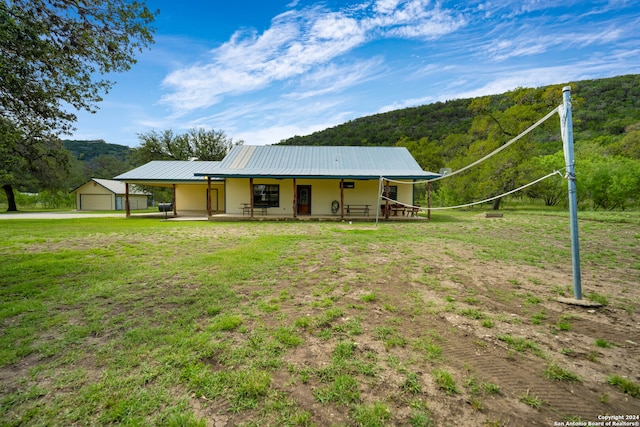 view of front of house with a mountain view, a porch, a garage, and a front lawn