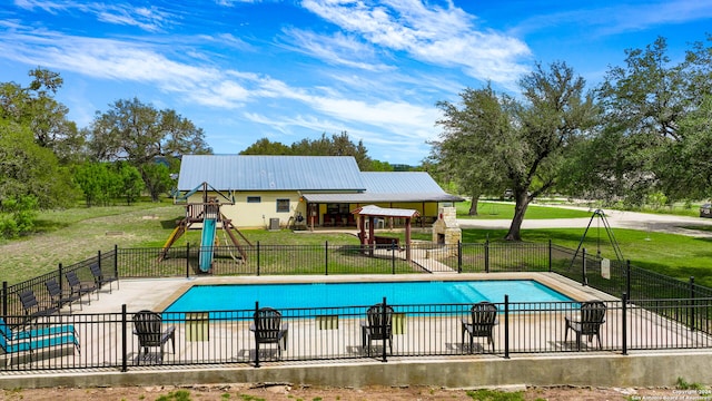 view of swimming pool featuring a playground, a lawn, and a patio