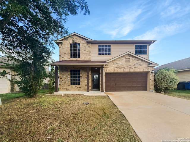 front of property featuring a garage, a front yard, and covered porch