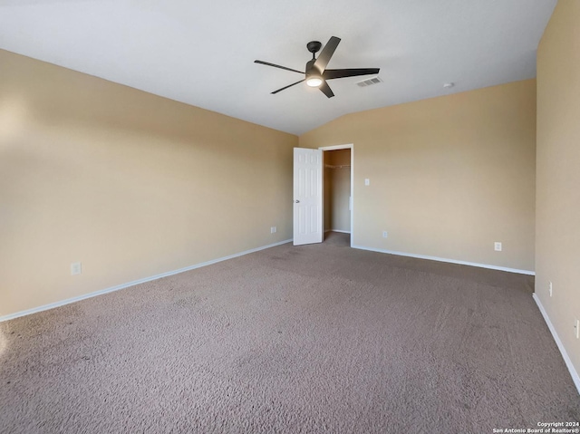 spare room featuring visible vents, baseboards, carpet, ceiling fan, and vaulted ceiling