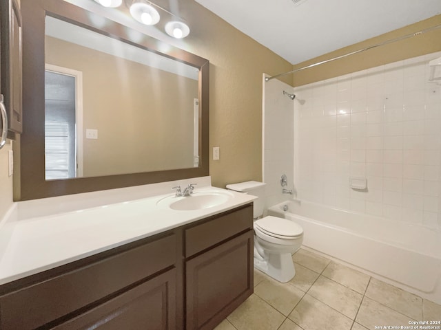 full bathroom featuring tiled shower / bath combo, vanity, toilet, and tile patterned flooring