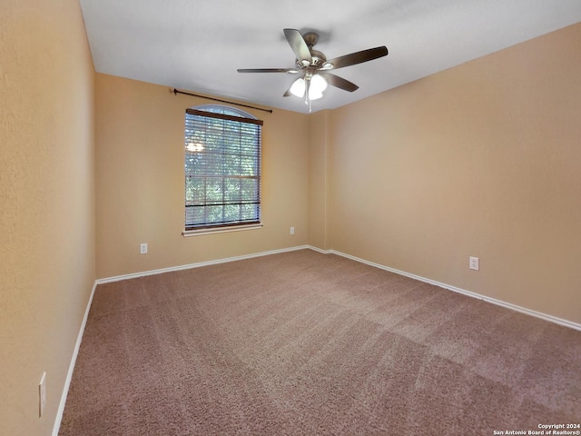 spare room with baseboards, a ceiling fan, and carpet floors