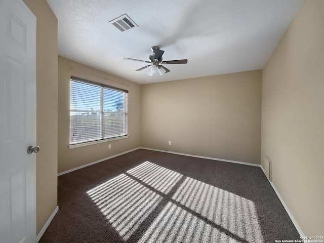 carpeted empty room featuring baseboards, visible vents, and ceiling fan