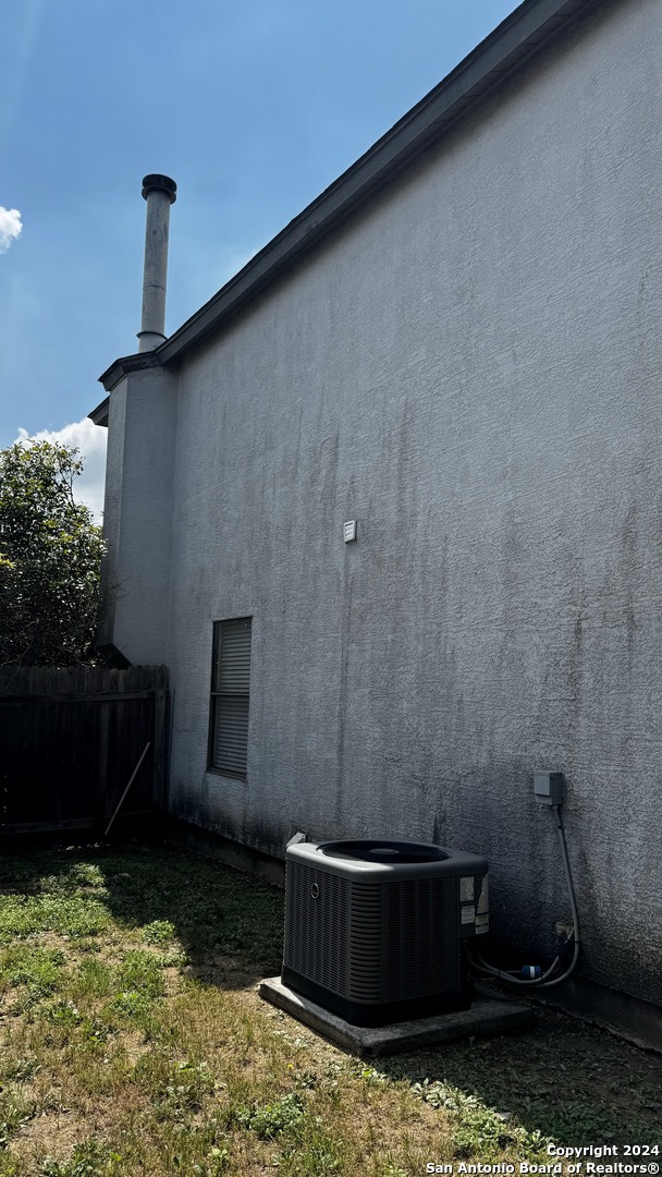 view of property exterior with cooling unit and a yard