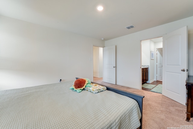 carpeted bedroom featuring ensuite bath