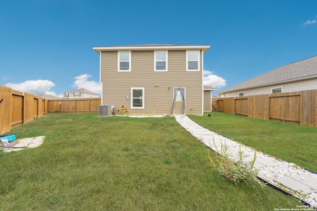 back of house featuring a yard and central AC unit