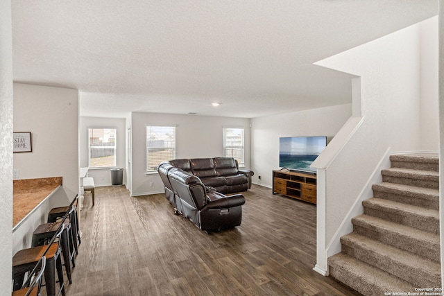 living room with dark hardwood / wood-style flooring and a textured ceiling