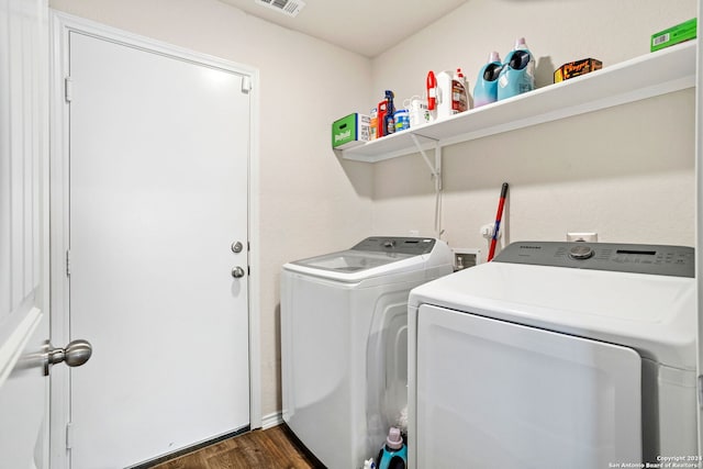 clothes washing area with dark wood-type flooring and washing machine and dryer