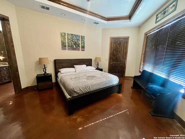 bedroom with connected bathroom, a raised ceiling, and crown molding