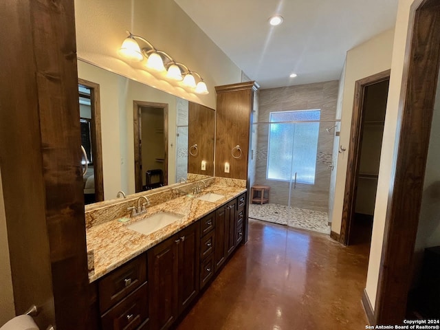 bathroom featuring tiled shower, vanity, and concrete floors