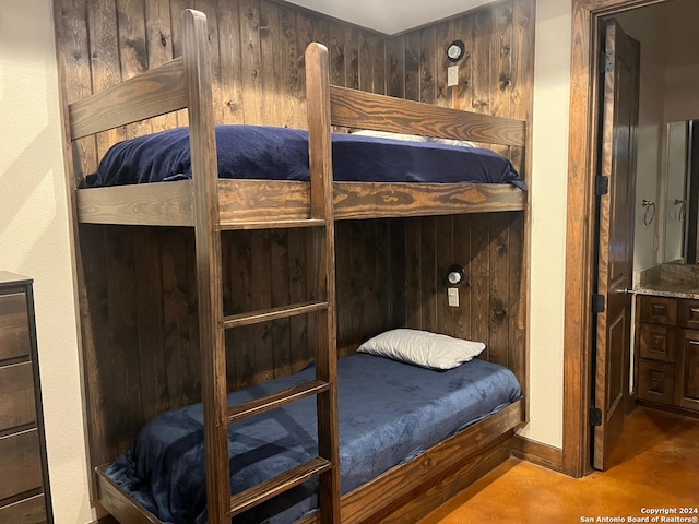 bedroom featuring wooden walls