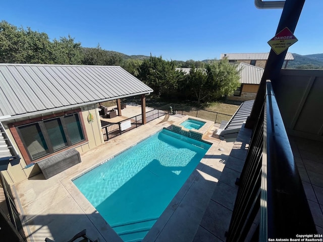 view of pool with a mountain view, an in ground hot tub, and a patio area