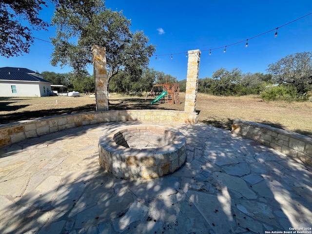 view of patio / terrace featuring a playground and an outdoor fire pit