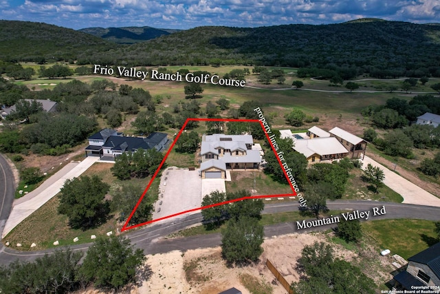 236 Tequila Sunrise, Concan, TX 78838 - aerial perspective of suburban area with a mountainous background and property boundaries highlighted