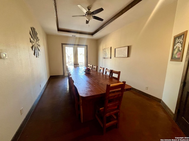 dining space featuring ceiling fan, a raised ceiling, and french doors