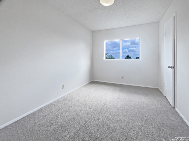 carpeted spare room with a textured ceiling