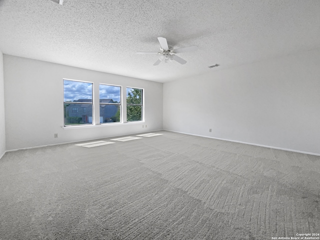 carpeted empty room featuring a textured ceiling and ceiling fan