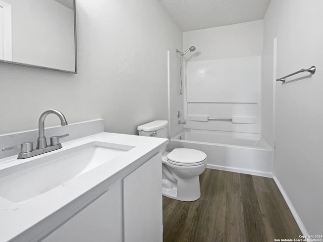 full bathroom with toilet, hardwood / wood-style floors, vanity, a textured ceiling, and shower / bath combination