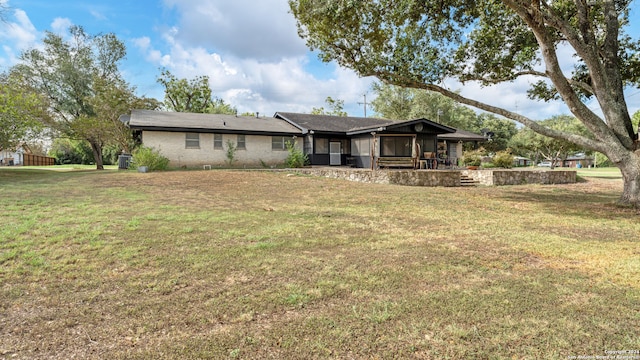 view of front of house with a front yard and a sunroom