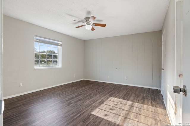 spare room with dark wood-type flooring, a textured ceiling, and ceiling fan