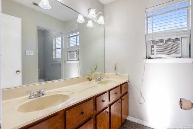 bathroom featuring cooling unit, vanity, toilet, and hardwood / wood-style flooring