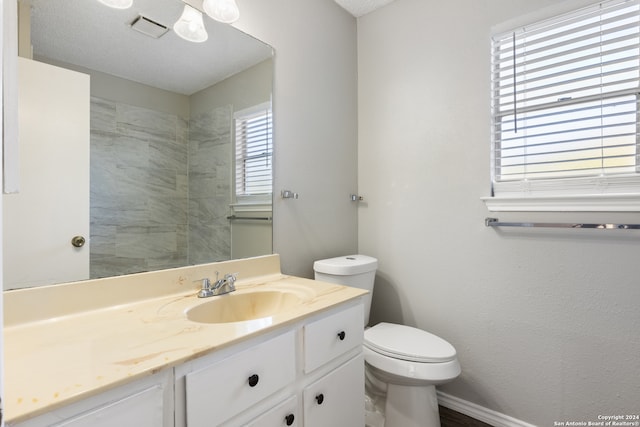 bathroom with vanity, toilet, and a textured ceiling