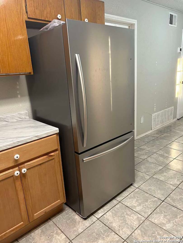 kitchen with stainless steel refrigerator and light tile patterned floors