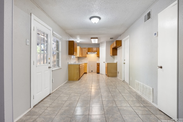 kitchen with a textured ceiling and light tile patterned floors