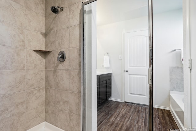 bathroom with vanity, wood-type flooring, and plus walk in shower