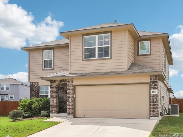 traditional-style home featuring central AC unit, fence, driveway, a garage, and brick siding