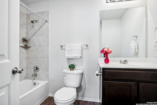 bathroom with baseboards, toilet, bathtub / shower combination, wood finished floors, and vanity