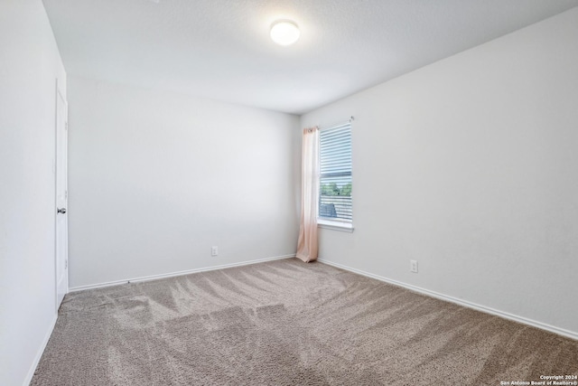 unfurnished room with baseboards and carpet