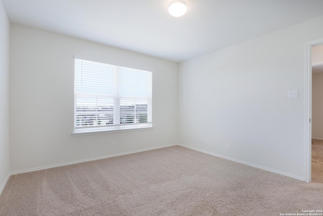 carpeted empty room featuring baseboards