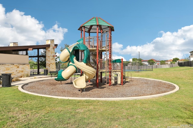 community playground with a yard and fence