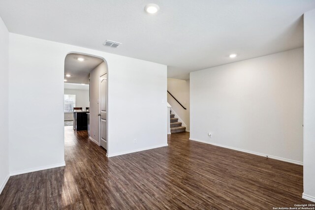 living room with a wealth of natural light, dark wood-type flooring, and lofted ceiling