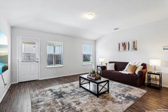 living area with lofted ceiling, wood finished floors, visible vents, and baseboards