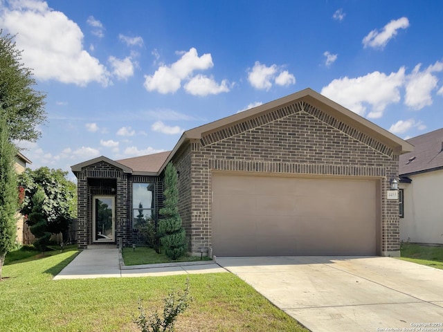 view of front facade with brick siding, driveway, a front yard, and a garage