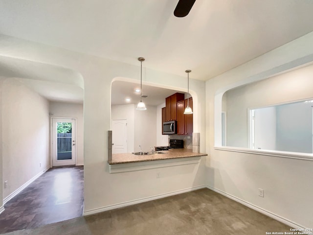 kitchen with black range oven, kitchen peninsula, sink, ceiling fan, and hanging light fixtures