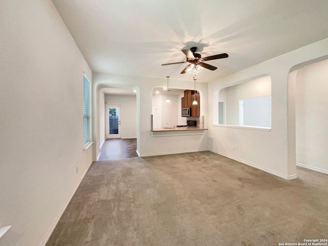 unfurnished living room with ceiling fan, carpet, and a healthy amount of sunlight