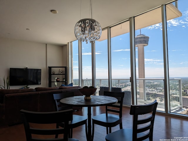 dining room featuring dark wood-type flooring, floor to ceiling windows, and an inviting chandelier