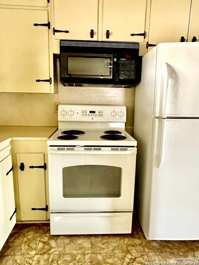 kitchen featuring white cabinets and white appliances