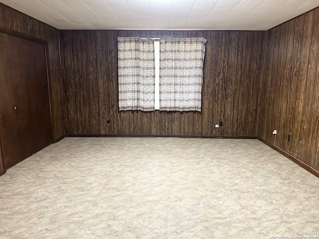 spare room with wood walls