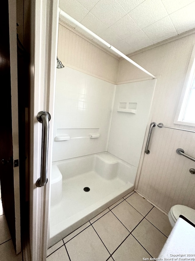 bathroom featuring toilet, a shower, and tile patterned floors