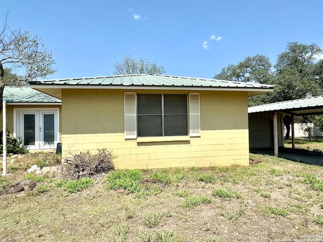 view of side of home featuring a carport and french doors