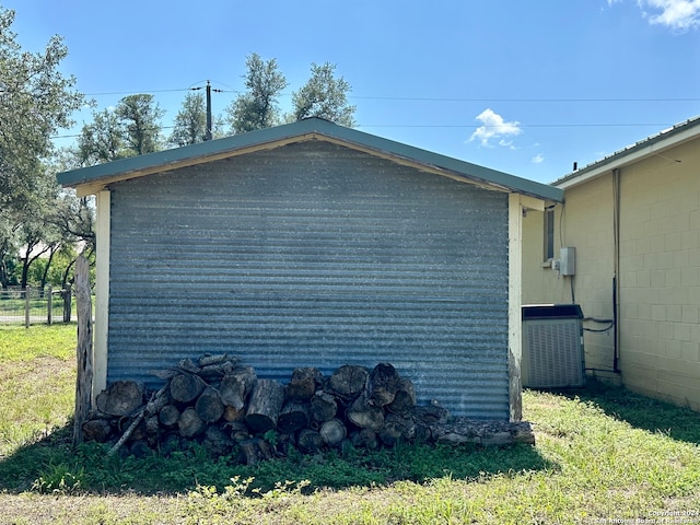 view of side of property with a lawn and cooling unit