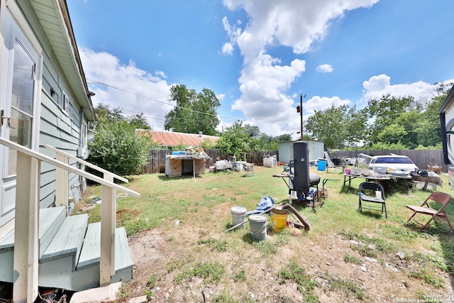 view of yard featuring an outdoor structure, a fenced backyard, and a shed