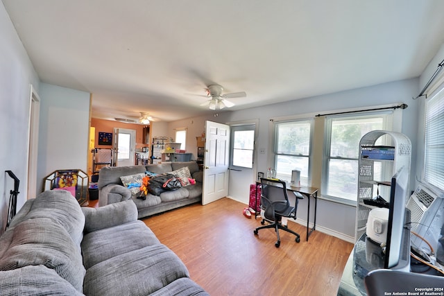 living room with baseboards, light wood-style floors, and ceiling fan